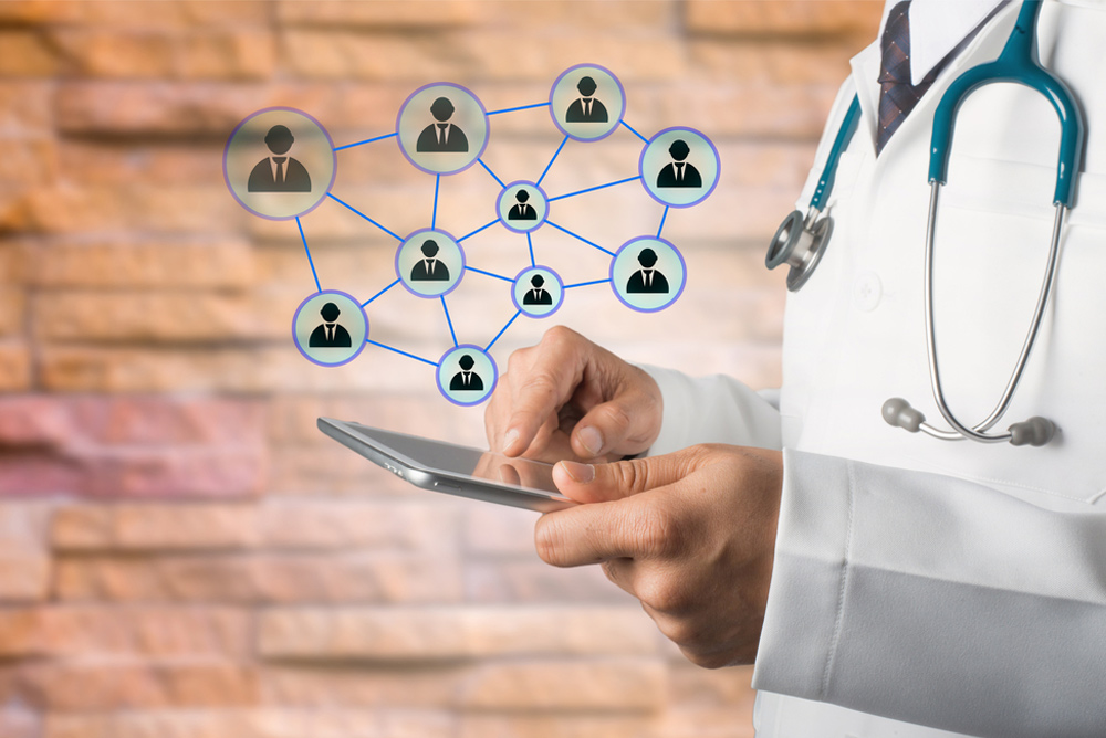 a doctor holding a tablet with a network of people on it